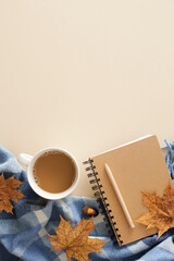 Warm desk setup in fall shades. Top view vertical photo of patchy blanket, pen, copybook, acorns, dry autumn leaves on pastel beige background with empty area for ad or note