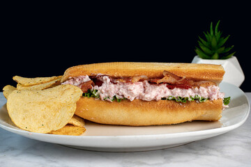 ham salad bacon sub  with a side of potato chips,