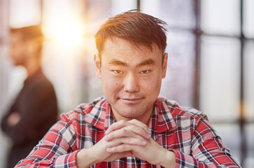 Obraz premium a successful businessman in a shirt sits at a table with folded hands.