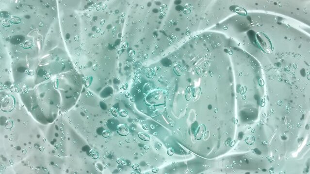 Transparent liquid gel background, clear serum texture. Motion, rotation of the beauty skincare product sample with bubbles. Top view. Macro Shot. High quality 4k footage