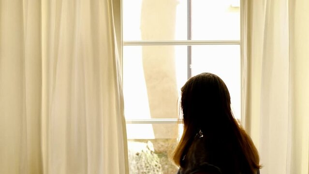 mature woman looks thoughtfully out old-fashioned window with wooden frame, bright light from window, concept Overcoming Loneliness through Self-Reflection, Exploring Loneliness Through Window Light