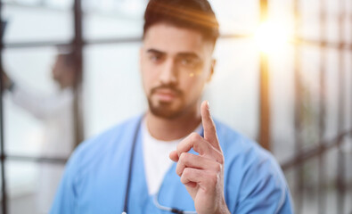 Doctor pointing up finger standing in the lobby of the hospital