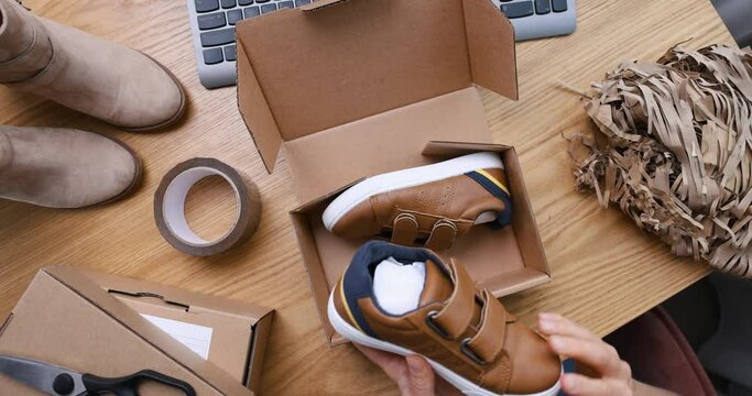 selling online, internet store owner, small business entrepreneur working at home office and packing shoe order parcel for delivery