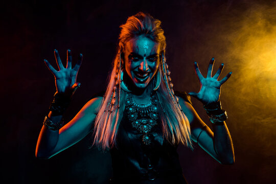 Photo of dangerous valkyrie woman evil laugh arms fingers scare foggy mist orange light isolated on black background