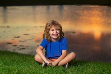 Kid on nature. Kids playing outdoors in summer park. Freedom and carefree. Happy childhood. Relaxing kid in green field during summer.