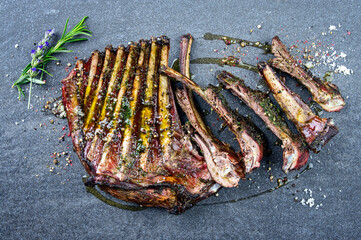 Traditional barbecue venison ribs with herbs and spice  served as top view on a gray board