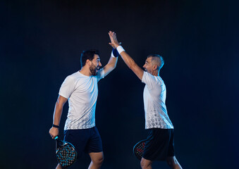 Padel tennis doubles. Two athletes players with racket. Man athlete with paddle racket on court...