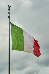 Flag of Italy against a cloudy sky.