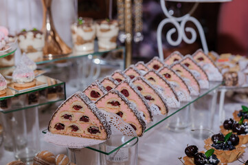 Sweet cakes at a wedding banquet. Catering, sweet festive buffet. Candy bar