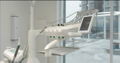 Dental chair without a patient. The interior of the medical room of a white modern dentistry with special equipment.