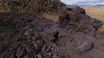 View of cracked lava crust or ingenious rock and steam cooled down from the 2021 eruption of Fagradalsfjall volcano in Geldingadalir Valley on Reykjanes Peninsula in Iceland.