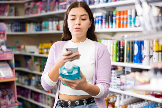 Young pretty woman taking photo of mouthwash in cosmetics store