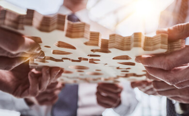 Business people holding wooden gears in office