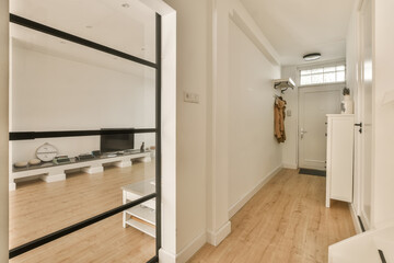an empty room with wooden floors and white walls, there is a large mirror in the corner to the right