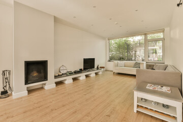 a living room with wood floors and white walls, including a fireplace in the corner to the floor is wooden