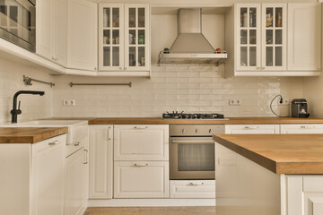 a kitchen with white cupboards and wood counter tops on the island in front of the sink is wooden top