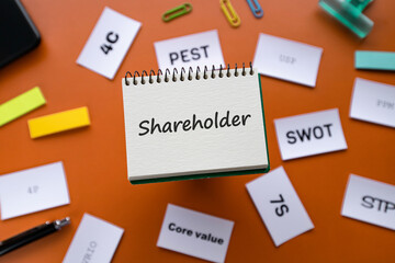 There is notebook with the word Shareholder. It is as an eye-catching image.