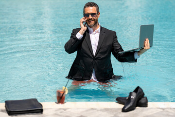 Crazy summer business. Fun business lifestyle. Handsome business man in suit using laptop in swimming pool. Funny businessman. Freelance concept, summer travel. Business success.
