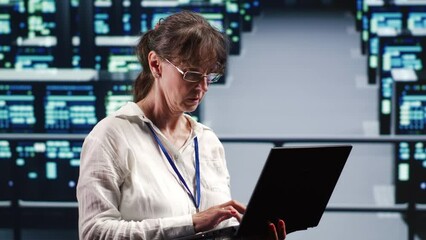 Elderly engineer in data center equipped to handle modern computing requirements, doing regular upgrades to components, increasing processing power, storage capacity and general efficiency