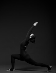 woman doing yoga poses on a dark background in full growth
