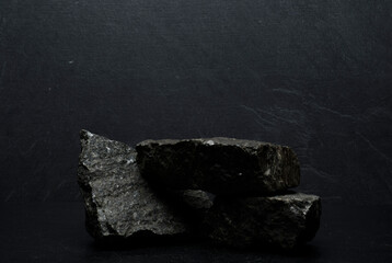 Naklejka premium podium stones.black stones on dark gray background for podium product presentation