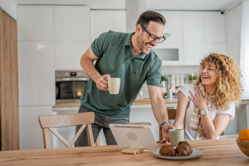Young couple man and woman enjoy cup of tea or coffee in the morning - Powered by Adobe