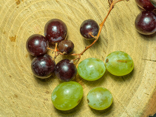 Grapes kishmish on a wooden background. The grapes are overripe. Harvest in the village. wine ingredient