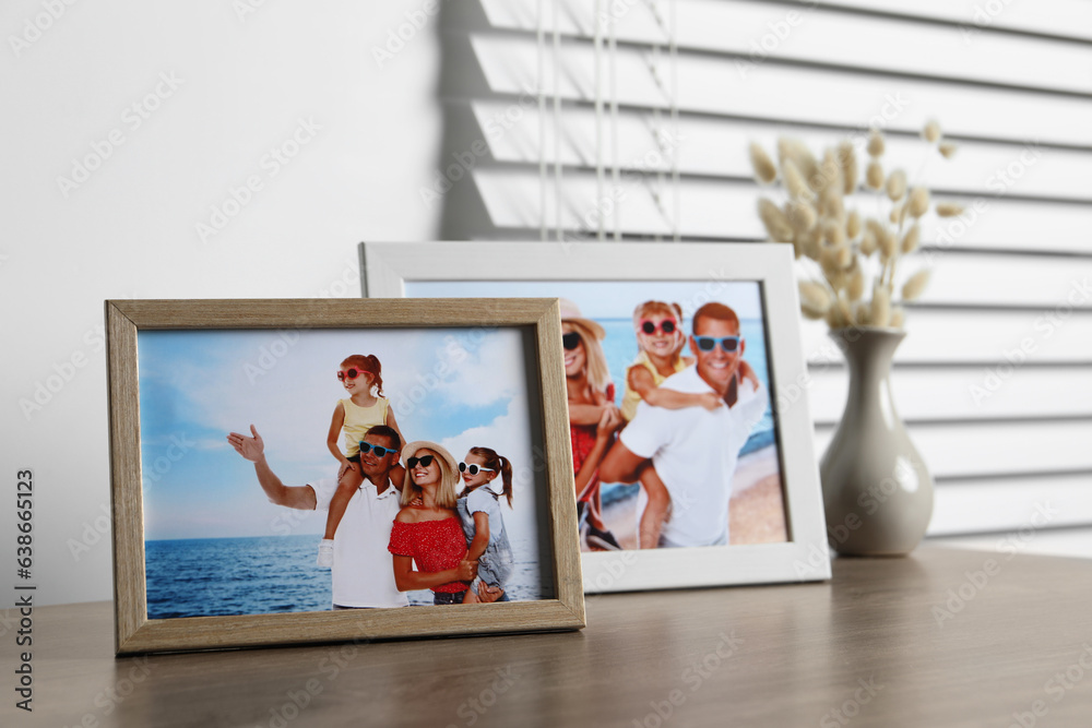 Poster Frames with family photos on wooden table indoors