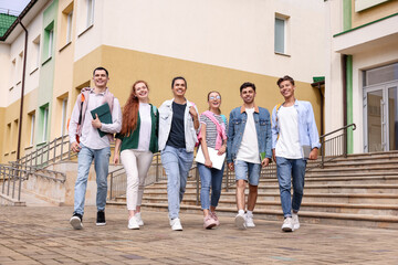 Obraz na płótnie Canvas Group of happy young students walking together outdoors