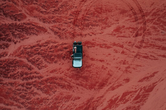 Aerial Image Of A Person Sitting On Top Of A Car In The Outback