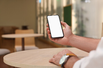 Man using smartphone at table in cafe, closeup