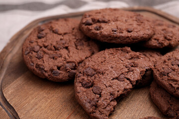 Tasty chocolate cookies on wooden board, closeup