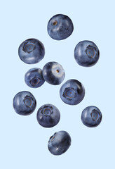 Many ripe blueberries falling on light blue background