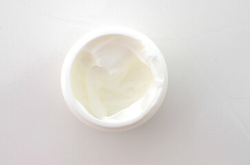 Fototapeta na wymiar Close-up of a small jar of white cream, a symbol of beauty care and skin health.