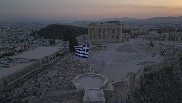 sunset curving over Greek flag towards Parthenon atop Acropolis