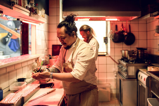 Young male chefs working in a japanese style sushi kitchen