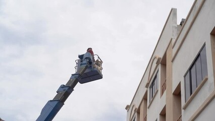 Worker uses the hydraulic lifting system to elevate the boom lift for goods