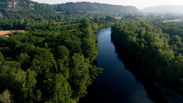 Aerial shot over a wild river in the Lot, the valley is beautiful with morning mist, Dordogne, France