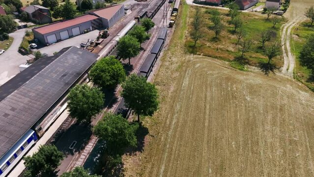 Steam train from Martel leaving the SNCF station with tourists, smoke coming out of the locomotive, aerial view in summer, Lot, France