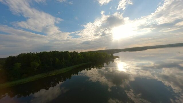 Drone flight over calm lake Baluosas in Lithuania during summer sunset