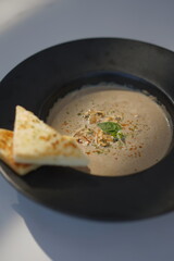 Mushroom Soup and Bread in a Black Bowl