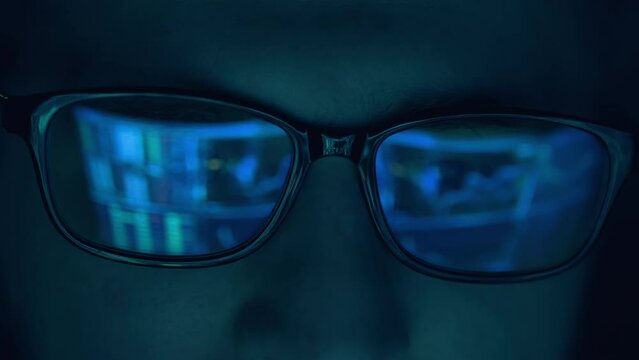 Closeup portrait of software engineer working on computer. Line of hack code run in reflection. Developer or hacker working on innovative application using computer. Big data or programming concept