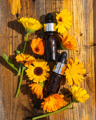 The calendula extract. Medicinal plants. Calendula oil bottle with pipette and calendula flowers. The calendula extract Medicinal plants. Selective focus.
