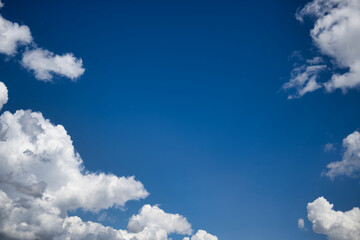 Blue sky with white cumulus clouds illuminated by daylight