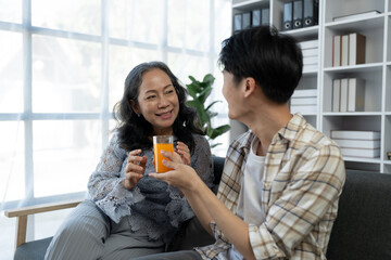 family holidays, hobbies Image of two couples, mother and son doing activities together. Reading books, tablets, talking, giving advice, resting, drinking orange juice to relax in the office in house