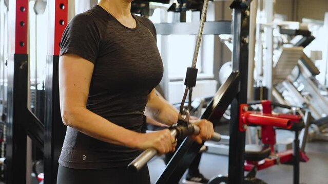 lat pull down working lats and traps in the gym, woman weight lifting staying healthy