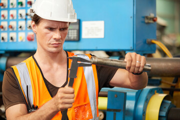 engineer or worker using calipers and measuring a steel pipe in the factory