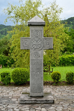 orthdoxes Kreuz aus stein im Holy Cross Monastery im unscharfem Hintergrund des Klostergartens