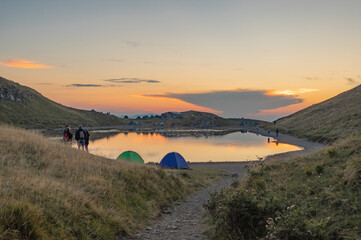 Il lago Scaffaiolo in montagna in Appennino emiliano d'estate al tramonto