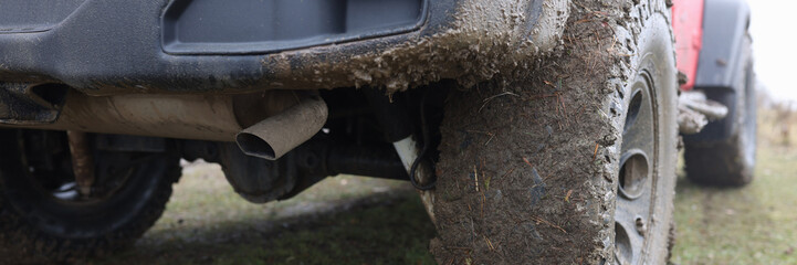 Dirty wheels of red offroad car close-up.
